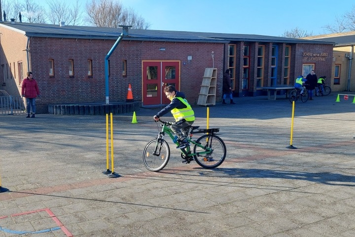 Leerling op fietsparkoers op schoolplein