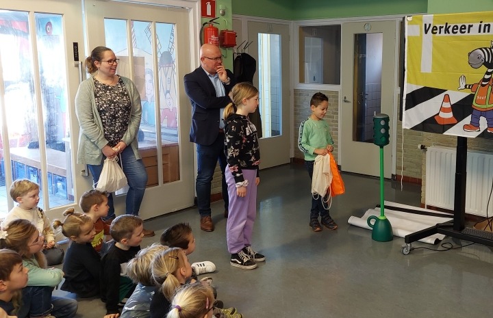 Wethouder en leerling bekijken lesmateriaal