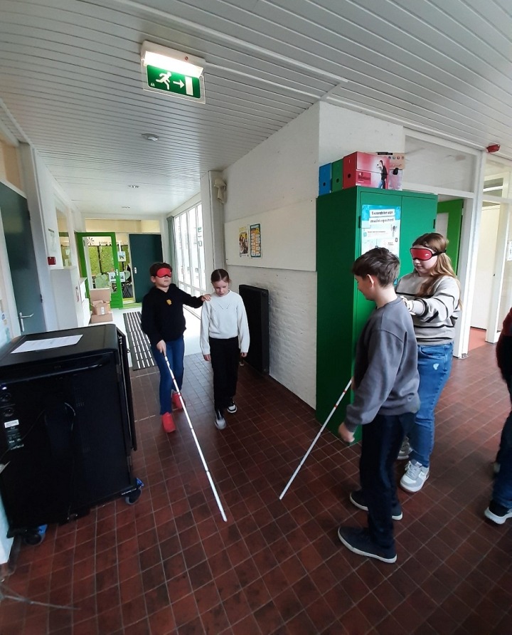 leerlingen zoeken hun weg met de taststok 