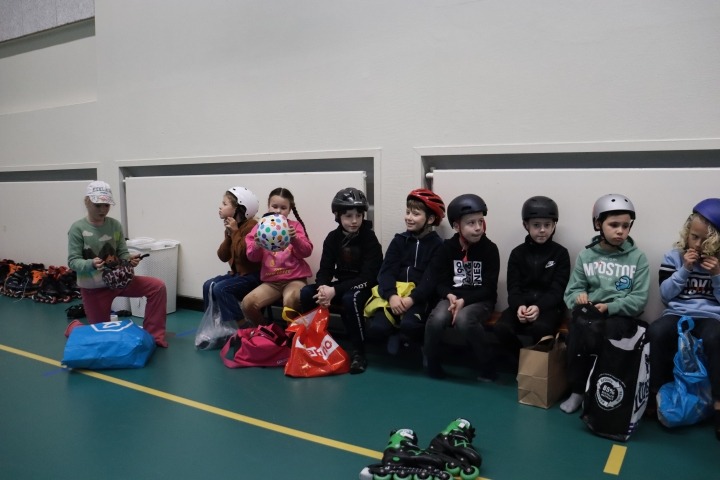 Kinderen zitten op bank bij skateclinic