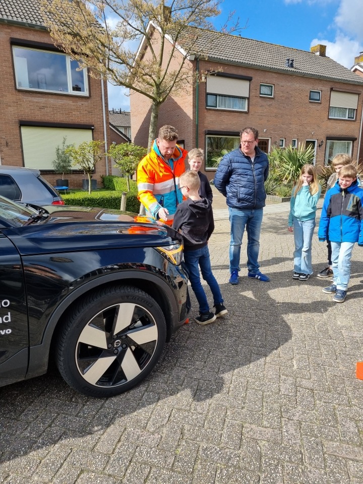 Leerlingen en instructeur bij auto tijdens remwegdemo