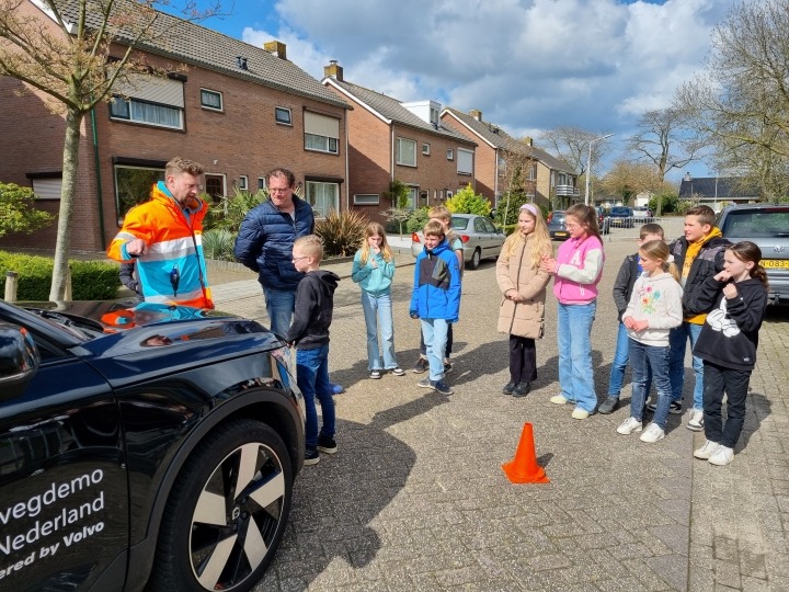 Leerlingen en instructeur bij auto tijdens remwegdemonstratie