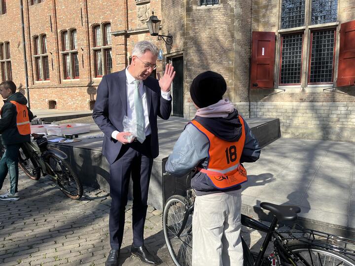 Gedeputeerde in gesprek met leerling op Abdijplein