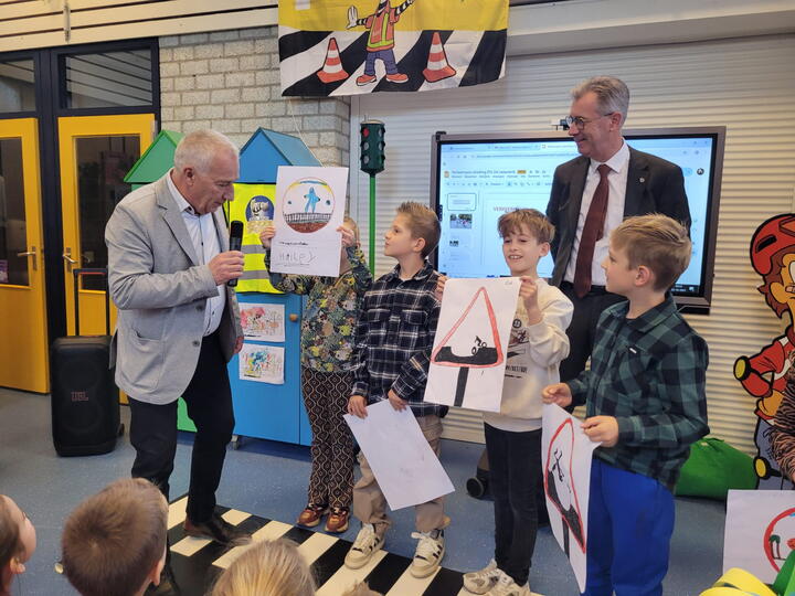 Wethouder bespreekt tekeningen met leerlingen