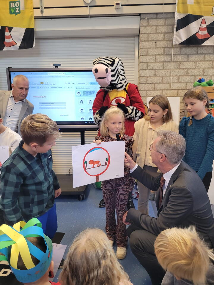 Gedeputeerde bekijkt tekening leerling