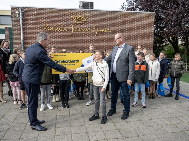 Gedeputeerde Harry van der Maas reikt de prijs van fietsmasters uit aan Koningin Juliana school