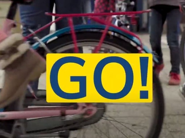 Afbeelding van het achterwiel van een fiets met woord "GO!" op een geel vlak